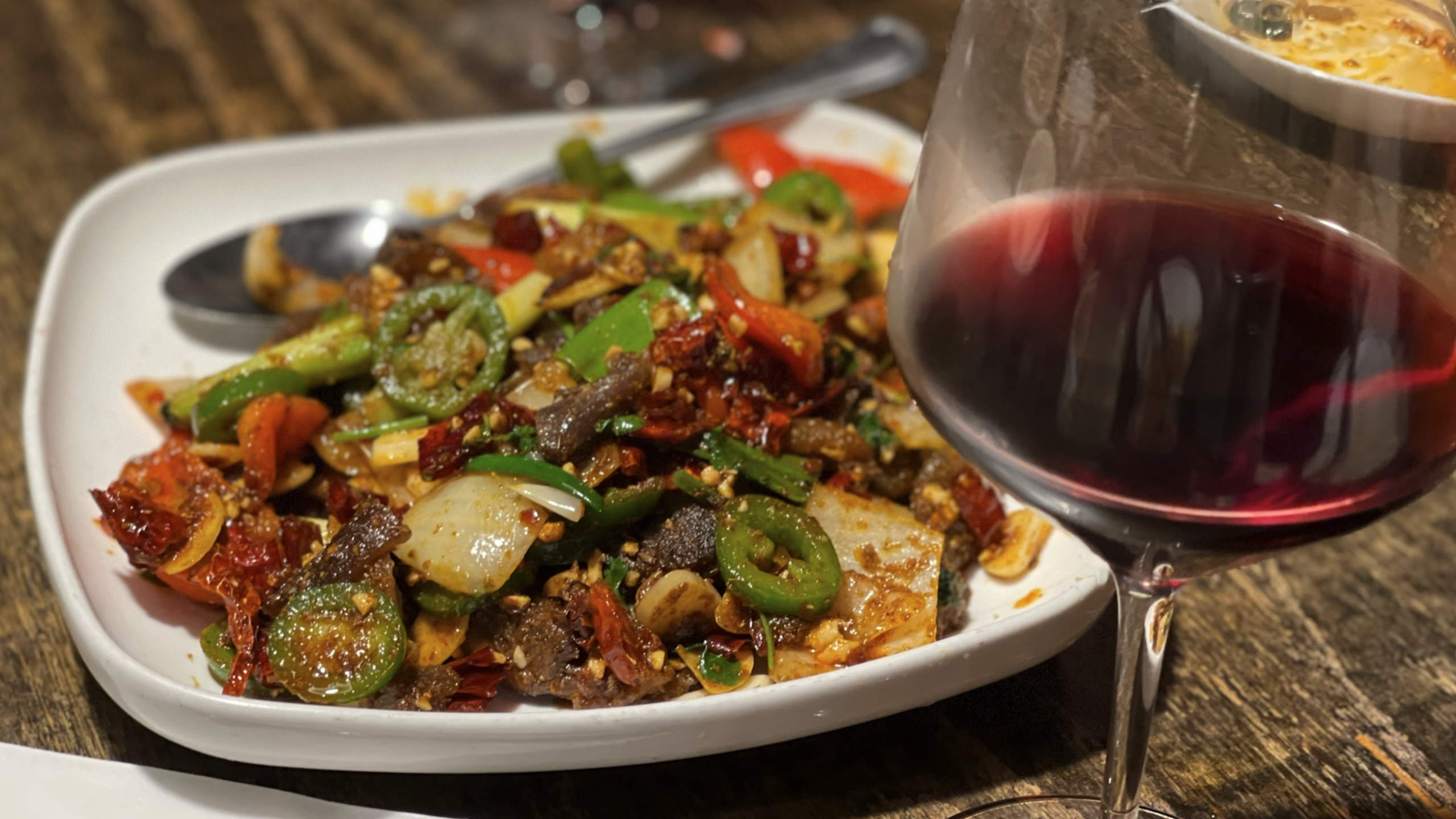 Stir fried beef and a glass of wine at Mala Sichuan in Montrose