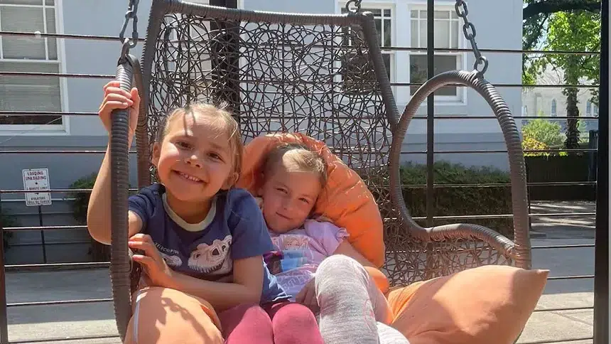 two children in a swing chair at Holman Draft Hall